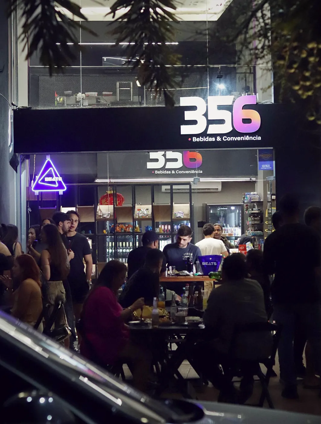 Clientes nas mesas em frente à loja